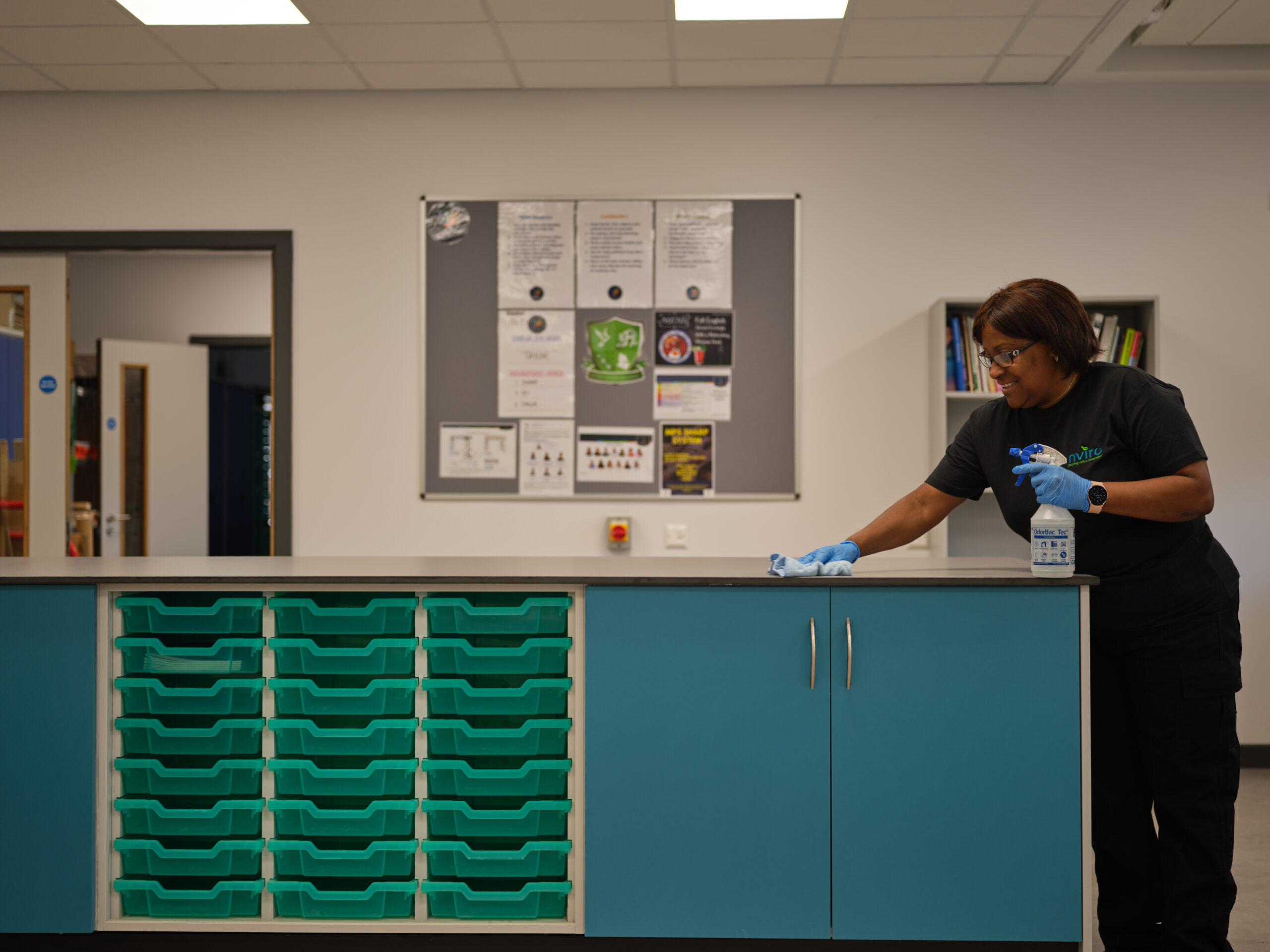 Cleaner smiling while cleaning surfaces in the room